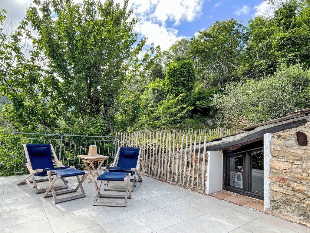 Sonnige Terrasse mit blauen Stühlen und Bergblick
