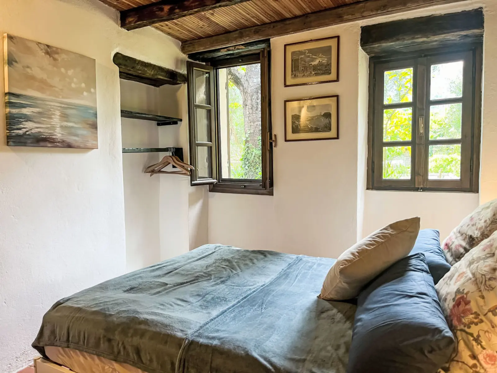 Zweites Schlafzimmer mit Doppelbett unter rustikaler Holzdecke